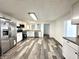 Spacious kitchen featuring stainless steel appliances, white cabinetry, and modern vinyl floors, perfect for cooking at 106 S Hancock St, Waynetown, IN 47990