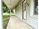 Concrete porch showing the house number and front door, with green lawn and shrubbery on the side at 106 S Hancock St, Waynetown, IN 47990