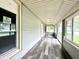 Enclosed sun room featuring wood-look flooring, neutral walls and ceiling, and multi-pane windows offering outdoor views at 106 S Hancock St, Waynetown, IN 47990