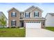 Charming two-story home with brick and vinyl siding, blue shutters, a manicured lawn, and a two car garage at 1065 Bent Branch Ln, Greenwood, IN 46143