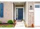 Close-up of a home's blue front door with decorative plants and visible house number on a brick facade at 1065 Bent Branch Ln, Greenwood, IN 46143