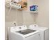 Laundry room with a front-load washing machine and dryer beneath a shelf with supplies at 1065 Bent Branch Ln, Greenwood, IN 46143
