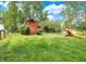 Spacious backyard features a red barn and playground, ideal for Gathering fun and entertaining at 10854 E 700 N, Wilkinson, IN 46186