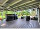 Spacious covered deck featuring comfortable seating, an outdoor kitchen area, and a view of the lush backyard at 10854 E 700 N, Wilkinson, IN 46186
