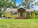 Charming home featuring green siding, brown shutters, and a covered porch with a decorative front door at 10854 E 700 N, Wilkinson, IN 46186
