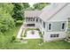 Aerial view of backyard featuring lush landscaping, stone patio with dining, mature trees and green home exterior at 11020 Florida Rd, Fortville, IN 46040
