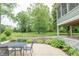 Inviting back patio with stone retaining wall and wrought iron table and chairs overlooking lush green backyard at 11020 Florida Rd, Fortville, IN 46040