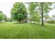 Expansive backyard featuring mature trees, lush green lawn, and a home with a wooden deck at 11020 Florida Rd, Fortville, IN 46040
