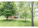 Expansive backyard featuring mature trees, a well-maintained lawn, and a home with a screened in porch at 11020 Florida Rd, Fortville, IN 46040