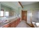 Well-lit bathroom featuring a double vanity, a glass-enclosed shower, and a soaking tub at 11020 Florida Rd, Fortville, IN 46040