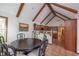 Charming dining area with vaulted ceilings, exposed beams, and a view of the kitchen and staircase at 11020 Florida Rd, Fortville, IN 46040