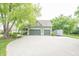 Exterior view of home's garage with ample parking space on concrete driveway and landscaping at 11020 Florida Rd, Fortville, IN 46040