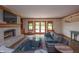 Cozy living room featuring a stone fireplace, built-in shelves, and access to the backyard at 11020 Florida Rd, Fortville, IN 46040