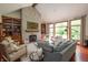 Sunlit living room showcasing a stone fireplace, built-in shelves, comfortable seating, and expansive windows at 11020 Florida Rd, Fortville, IN 46040