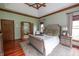 Comfortable main bedroom with tray ceilings, hardwood floors, large windows, and an ensuite bathroom at 11020 Florida Rd, Fortville, IN 46040