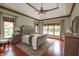 Serene main bedroom with tray ceilings, hardwood floors, multiple windows, and stylish furnishings at 11020 Florida Rd, Fortville, IN 46040