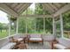 Cozy screened porch with white trim and furniture, string lights, and view of the lush backyard at 11020 Florida Rd, Fortville, IN 46040