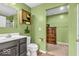 Bathroom with green walls, vanity, toilet, and a glimpse into the walk-in closet at 123 Campus Ln, Greenwood, IN 46143
