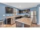 A well-lit kitchen with stainless steel appliances, dark cabinets, and an island with countertop seating at 123 Campus Ln, Greenwood, IN 46143