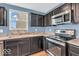 Close-up view of a kitchen features stainless steel appliances, dark cabinets, and a stainless sink at 123 Campus Ln, Greenwood, IN 46143