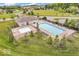 The community pool complex is surrounded by a fence, landscaping, trees, and buildings at 123 Campus Ln, Greenwood, IN 46143