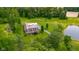 Aerial view of the home with surrounding lush greenery, a pond, and ample parking at 12383 S 25 W, Columbus, IN 47201