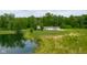 Scenic aerial view of the home, grounds, and tranquil pond, showcasing the property's expansive natural beauty at 12383 S 25 W, Columbus, IN 47201
