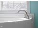 Close up detail of a brushed metal faucet on a luxurious soaking tub with colorful walls at 12383 S 25 W, Columbus, IN 47201