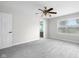 Bright bedroom with gray carpet, a ceiling fan, and a view to an en-suite bathroom at 12383 S 25 W, Columbus, IN 47201