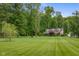 Home exterior featuring a lush green lawn, mature trees, and well-maintained landscaping at 12383 S 25 W, Columbus, IN 47201