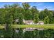 Beautiful view of home with pond reflecting the house, surrounded by lush trees at 12383 S 25 W, Columbus, IN 47201