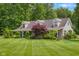 A home exterior featuring tan siding and lush greenery at 12383 S 25 W, Columbus, IN 47201