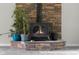 Stone fireplace with digitally enhanced flames is surrounded by plants at 12383 S 25 W, Columbus, IN 47201