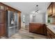 Spacious kitchen featuring stainless steel fridge, wood cabinets, granite countertops, and hardwood style flooring at 12383 S 25 W, Columbus, IN 47201