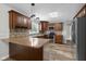 Well-lit kitchen featuring granite countertops, wooden cabinets, stainless steel appliances, and mosaic backsplash at 12383 S 25 W, Columbus, IN 47201