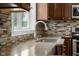 Close-up on kitchen with granite countertops, mosaic backsplash, stainless steel faucet and a bright window at 12383 S 25 W, Columbus, IN 47201