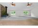 Spacious living room featuring two ceiling fans, fireplace and large windows at 12383 S 25 W, Columbus, IN 47201