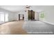 Open living room with a stone fireplace, hardwood and carpet flooring, and natural light from large windows at 12383 S 25 W, Columbus, IN 47201