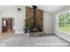 Living room featuring a stone fireplace, plant accents, carpet and bright windows at 12383 S 25 W, Columbus, IN 47201