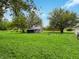 Back yard with lush green grass, storage shed and wooded area behind the property at 12508 N Jackley Rd, Elwood, IN 46036