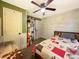 Cozy bedroom featuring unique wood paneling, a ceiling fan, and comfortable furnishings at 12508 N Jackley Rd, Elwood, IN 46036