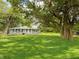 Exterior shot showing the manicured lawn and mature trees surrounding the home at 12508 N Jackley Rd, Elwood, IN 46036