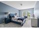 This blue bedroom features a large bed and two windows offering lots of light at 12624 Majestic Way, Fishers, IN 46037