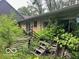 The back of a house with overgrown weeds and other garbage at 130 Napanee Dr, Carmel, IN 46032