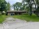 Modest single-story home with a red front door, attached garage and an unkempt front yard at 130 Napanee Dr, Carmel, IN 46032