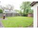 Spacious backyard with grass, wooden fence, mature trees, and detached garage in the distance at 1331 N Berwick Ave, Indianapolis, IN 46222