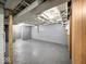 Unfinished basement area with painted floors and walls, exposed ceiling beams and rafters, and utility access at 1331 N Berwick Ave, Indianapolis, IN 46222