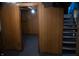 Unfinished basement with paneled walls, open doorway, and stairs to the upper level at 1331 N Berwick Ave, Indianapolis, IN 46222