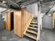 Unfinished basement with stairs, paneled compartment, and visible ceiling rafters and pipes at 1331 N Berwick Ave, Indianapolis, IN 46222