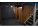 Unfinished basement featuring paneled walls, exposed pipes, and stairs to the upper level at 1331 N Berwick Ave, Indianapolis, IN 46222